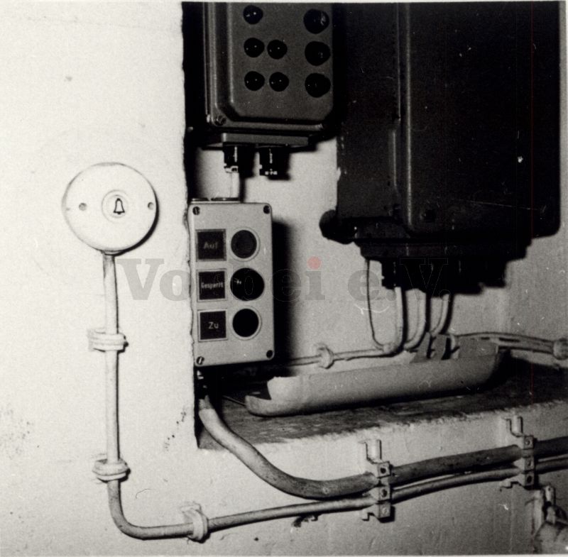 Bild 7: Drucktaster mit Warnleuchte neben Außenseite einer Schleusentür montiert.