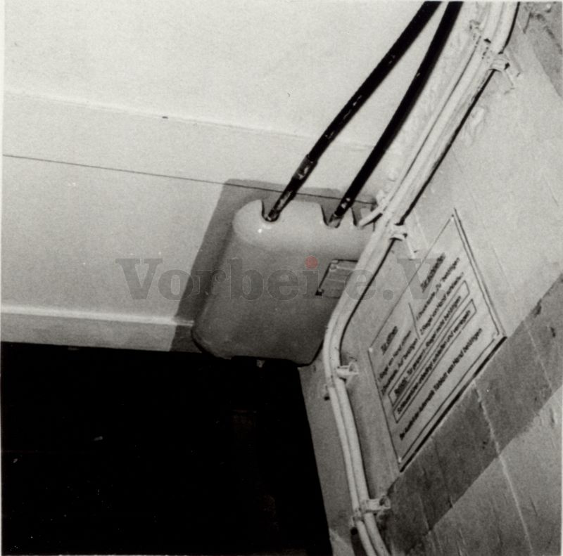 Bild 11: Sicht auf Meflex-Kabel und Verkleidung der Zwangsverriegelungsmechanik in rechter oberer Durchgangsecke der äußeren Schleusentür.