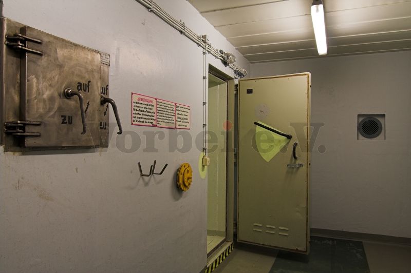 Der Auskleideraum (Raum 54) mit der Kleiderrutsche und geöffneter Schleusentür zum Duschraum (Raum 56).