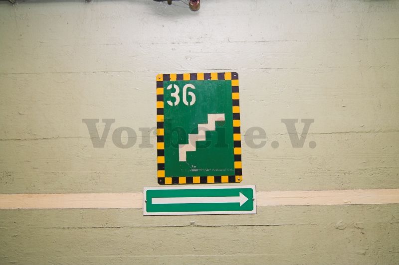 In einer anderen GSVBw weisen diese nachleuchtenden Schilder im Bereich des Eingangs (Raum 51) auf eine steigende Treppe mit 36 Stufen und auf die Richtung des Fluchtweges hin.