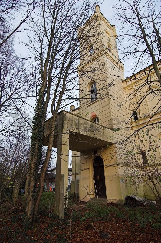 Der Turm an der Stirnseite. Ein Balkon dient als Überdachung des Eingangsbereiches.