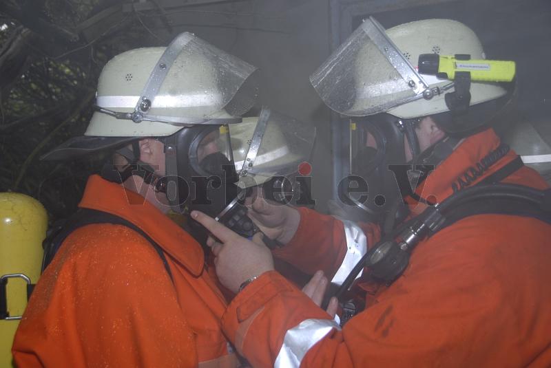 Feuerwehr-Einsatzkräfte beim Anlegen des Atemschutzgerätes.