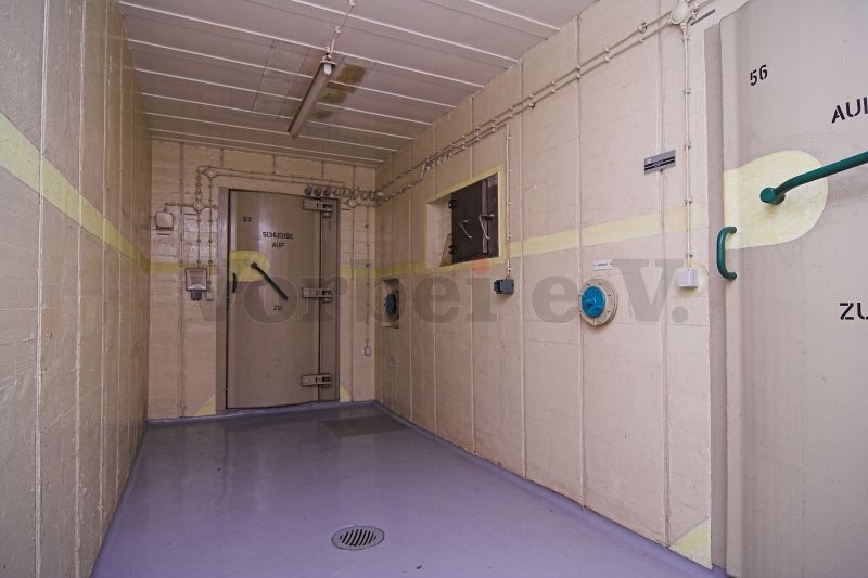 Der Auskleideraum (Raum 54) mit Schleusentür zum Raum 53 (Vorflur Dekontaminierungsanlage). Die Tür auf der rechten Seite führt in den Duschraum (Raum 56).