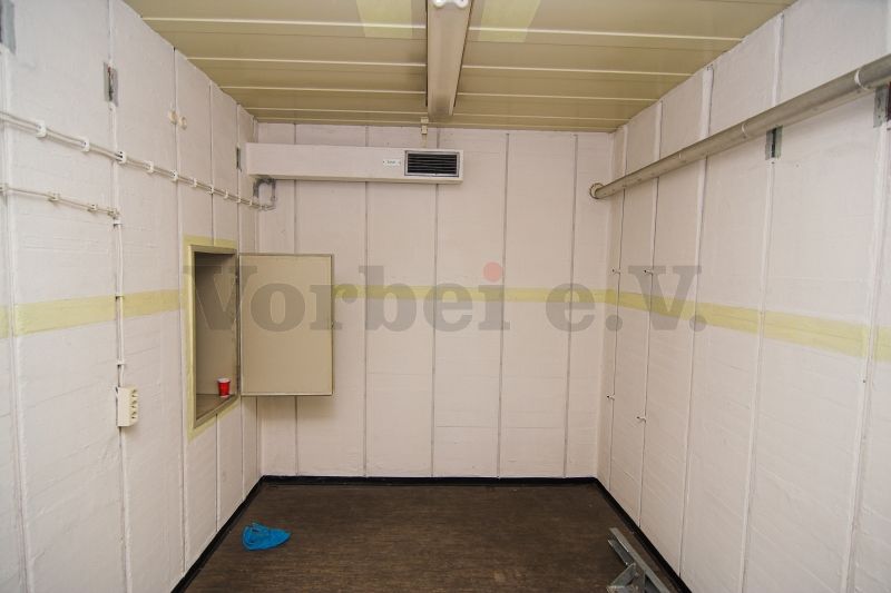 Der Lagerraum für saubere Bekleidung (Raum 59) mit Durchreiche in den Ankleideraum (Raum57).