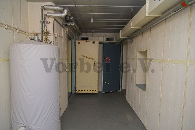 Raum 57: Ein elektrisch beheizter Warmwasserspeicher sorgte für warmes Wasser in der Dusche (Raum 56). Die Durchreiche an der rechten Wand führt in den Raum 59 (Lagerraum für saubere Bekleidung).