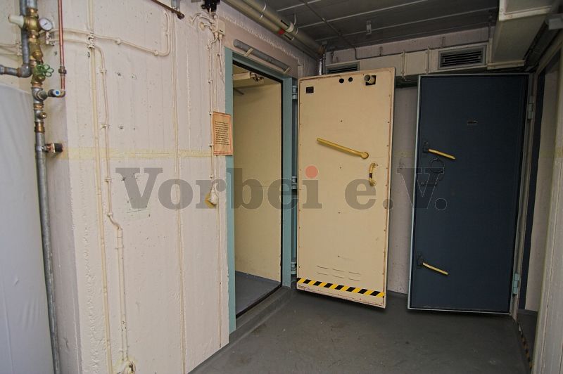 Links befindet sich die Schleusentür zur Dusche (Raum 56). Die rechte Tür führt in das WC des Ankleideraumes (Raum 58).