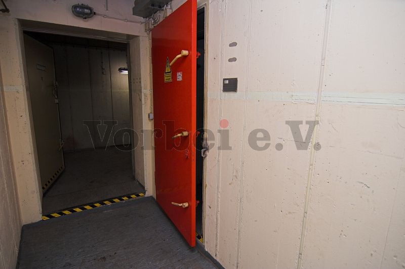 Raum 45: Geöffneter Zugang zum Raum 36 (Lager für Ersatzteile, Geräte und Fernmeldetechnik). Die geschlossene Tür führt in den Transformatorraum (Raum 21).