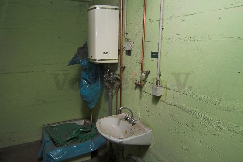 In einem Nebenraum der Zugangsschleuse befindet sich eine Dekontaminationsdusche mit dazugehörigem Warmwasserbereiter. Zum Schutz vor Verschmutzungen wurde die Dusche mit Folie abgedeckt.