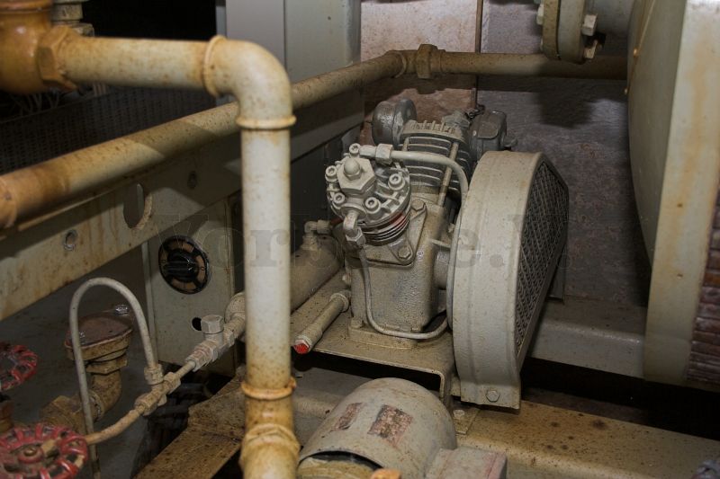 Das Foto zeigt einen Kompressor. Dieser ist ein Bestandteil der Notstartvorrichtung für die Dieselmaschinensätze im Bunker. Er dient zur Befüllung der Notstart-Anlassflasche.