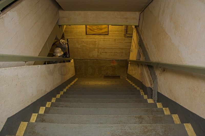 Das Foto zeigt die Treppe zwischen dem Erdgeschoss und dem ersten Obergeschoss des Bunkers. In beiden Stirnseiten des Schutzbaus befindet sich jeweils eine Treppenanlage.