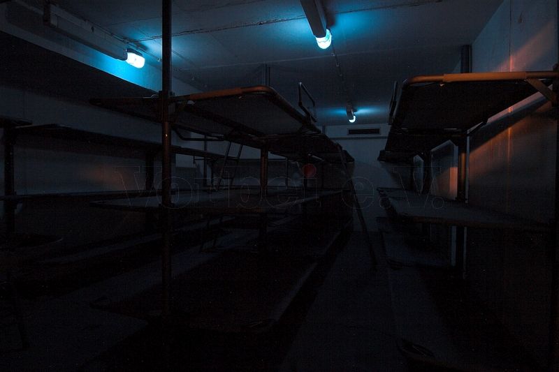 Die Aufnahme zeigt den gleichen Liegeraum im Bunker mit eingeschalteter Blaulicht-Beleuchtung. Die Beleuchtung kann direkt im Liegeraum mit einem Drehschalter gesteuert werden.