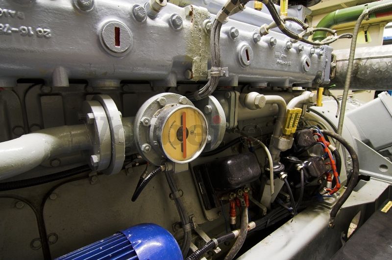 Motor der Primärkreis-Kühlwasserpumpe (links unten im Bild). Der Durchflussanzeiger (Bildmitte) dient zur Funktionskontrolle des Primärkühlkreises. Rechts daneben befinden sich zwei Thermometer zur Kontrolle der Öltemperatur.