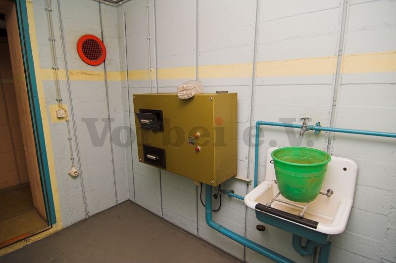 Im Raum 30 einer anderen GSVBw befindet sich dieses Gerät, das ebenfalls zur Entsorgung von Damen-Hygieneartikeln dient. In dieser Vorrichtung wurde das durch die Klappen eingelegte Entsorgungsgut mit einem Mahlwerk zerkleinert und in das Abwassersystem der GSVBw eingeleitet.