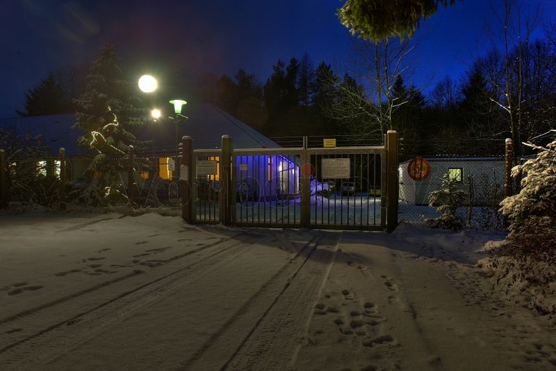 Abendliche Winterstimmung: Die GSVBw 22 mit eingeschaltetem Suchscheinwerfer und beleuchtetem Unterkunftsgebäude.