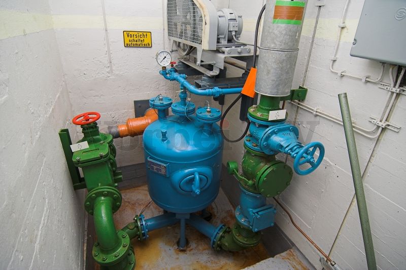 Der Abwasser-Druckbehälter der Fäkalienhebeanlage mit Füllstandssonden. Die Zuleitung befindet sich auf der linken Seite. Über das Abwasserrohr auf der rechten Seite des Druckbehälters wird der Behälterinhalt entleert.