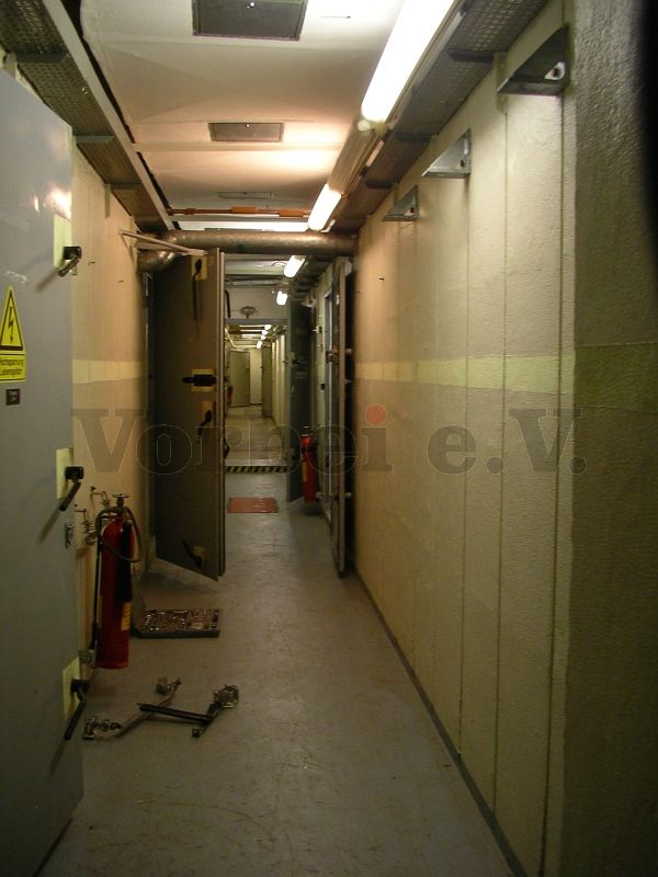 Ausstattung des Fernmeldebunkers mit originalen CO2-Handfeuerlöschern: Wie hier im Raum 45 (Flur Maschinenräume) erfolgt die Befestigung mit speziellen schwingungsdämpfenden Wandhalterungen für den Schutzbau-Einsatz.