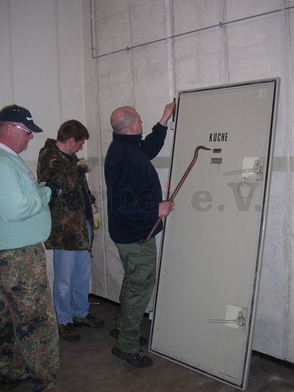 Die Schutzraumtür der Notküche lagert im Lebensmittellager (Raum 32). Zunächst werden die Türbolzen entfernt.