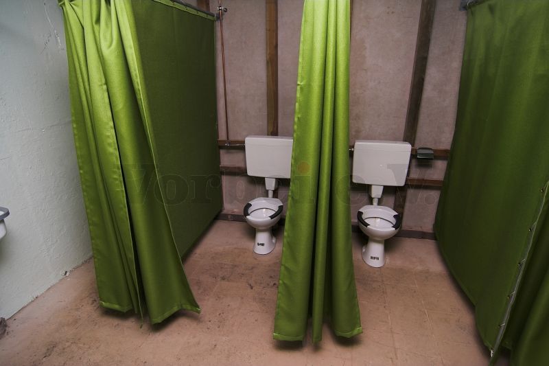 Die einzelnen WC-Kabinen werden durch Vorhänge verschlossen.