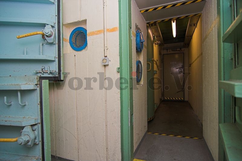 Blick von der Schleuse aus durch die geöffnete Panzerdrucktür in den Vorflur der Dekontaminationsanlage (Raum 53).
