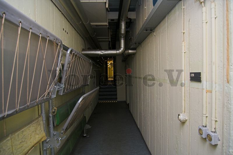 Blick in Richtung Eingangsflur (Raum 40). Im rechten Bildbereich befindet sich das Türschild für den Raum 34N (Lagerraum für Sanitätsmaterial).