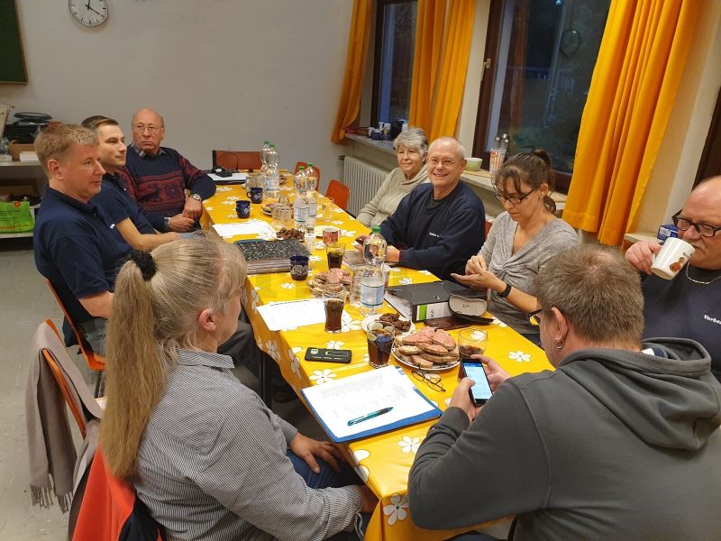 Auf dem Foto werden die Vereinsmitglieder des Vorbei e.V. gezeigt, Die Personen sitzen an einem Tisch in der GSVBw 22 Elmlohe.