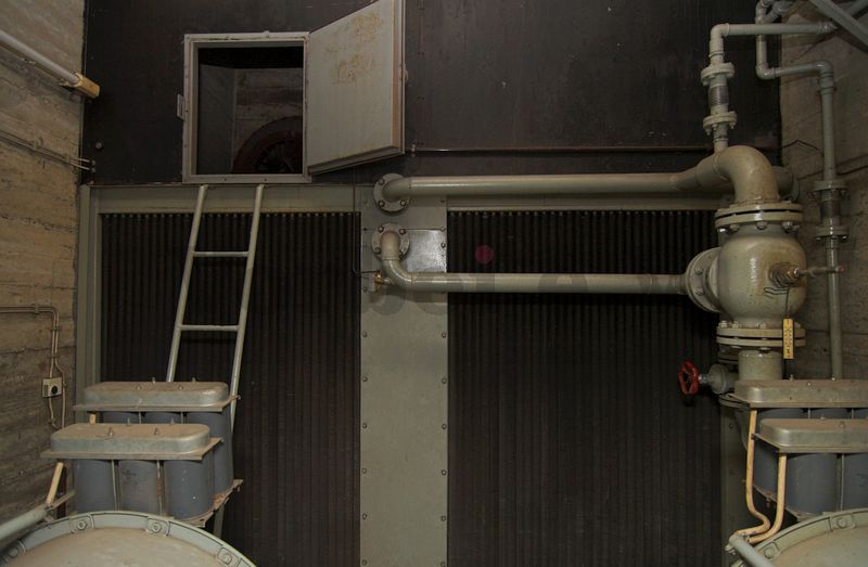 Bevor der Luftstrom das erste Obergeschoss des Filteranbaus wieder verlässt, werden die Kühler für das Kühlwasser der Dieselmaschinensätze durchströmt. Die Kühler befinden sich direkt hinter dem Luftaustritt der Axial-Gebläse. Durch die geöffnete Revisionstür wird ein Zugang zur Rückseite der Kühler ermöglicht.