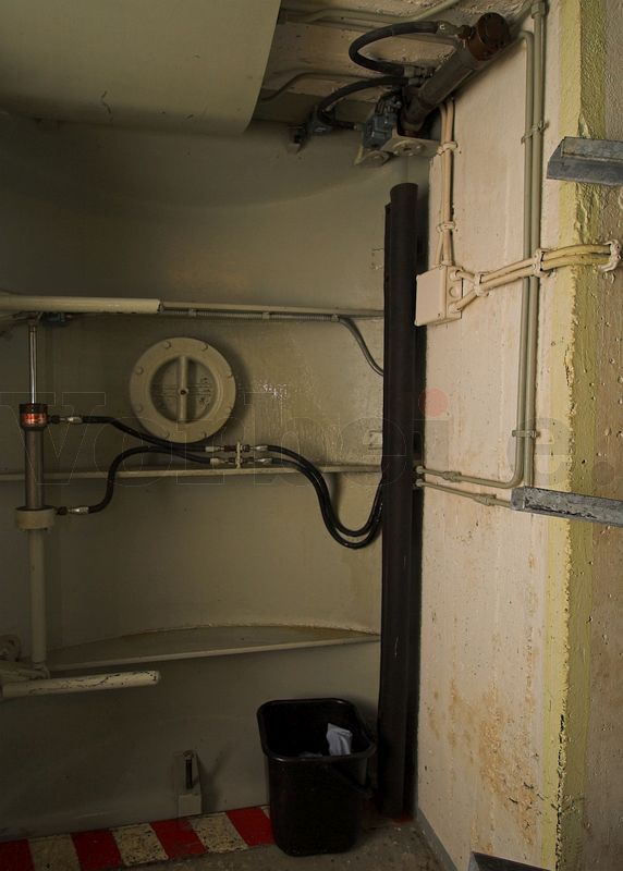 Zum Auffangen des austretenden Hydraulik-Öls wurde ein Eimer, gefüllt mit einer Schicht Ölbindemittel, aufgestellt. Die Schadensstelle befindet sich hinter der flexiblen Schutzabdeckung im Knickbereich der Schleusendrucktür (auf der rechten Türseite). Auf der linken Türseite ist der Hydraulikzylinder platziert, der die beiden Vorreiber betätigt und damit die Tür fest verriegelt. Zum Auffangen des austretenden Hydraulik-Öls wurde ein Eimer, gefüllt mit einer Schicht Ölbindemittel, aufgestellt. Die Schadensstelle befindet sich hinter der flexiblen Schutzabdeckung im Knickbereich der Schleusendrucktür (auf der rechten Türseite). Auf der linken Türseite ist der Hydraulikzylinder platziert, der die beiden Vorreiber betätigt und damit die Tür fest verriegelt.