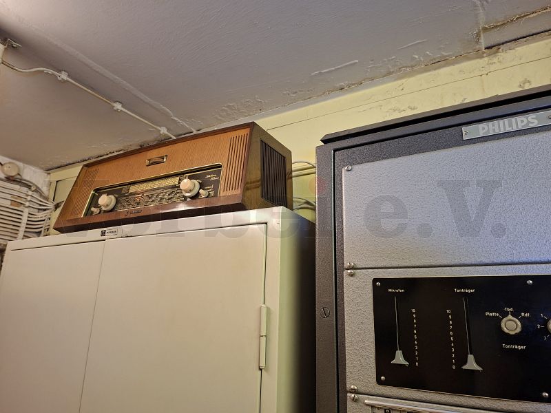 Der eingeschaltete Rundfunkempfänger ist nach der für Röhrengeräte typischen Aufwärmzeit in der Lage, mehrere Radiosender im Bunker zu empfangen. Der eingeschaltete Rundfunkempfänger ist nach der für Röhrengeräte typischen Aufwärmzeit in der Lage, mehrere Radiosender im Bunker zu empfangen.
