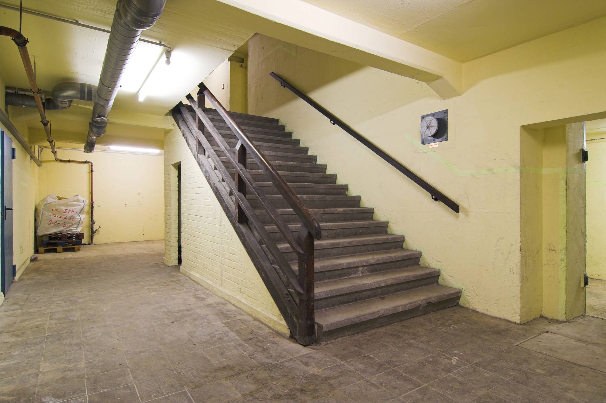 Treppenbereich einer Zivilschutzanlage im Stadtteil Badenstedt der Landeshauptstadt Hannover. Es handelt sich um eine Anlage aus dem „Nutzbarmachungsprogramm 1977“, einem stark vereinfachten Bauprogramm. Aufgrund eingeschränkter Luftkühlung war die Aufenthaltsdauer auf etwa 10 Stunden begrenzt.