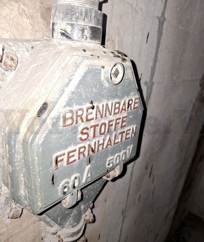 Fundstück: Dieser Anschlusskasten ist an der Umfassungswand des Bunkers befestigt und befindet sich in einem schmalen und schwer zugänglichen Bereich hinter einem der beiden Notwasser-Vorratsbehälter. Da keine Leitungswege erkennbar sind, war für uns die Funktion zunächst unklar. Fundstück: Dieser Anschlusskasten ist an der Umfassungswand des Bunkers befestigt und befindet sich in einem schmalen und schwer zugänglichen Bereich hinter einem der beiden Notwasser-Vorratsbehälter. Da keine Leitungswege erkennbar sind, war für uns die Funktion zunächst unklar.