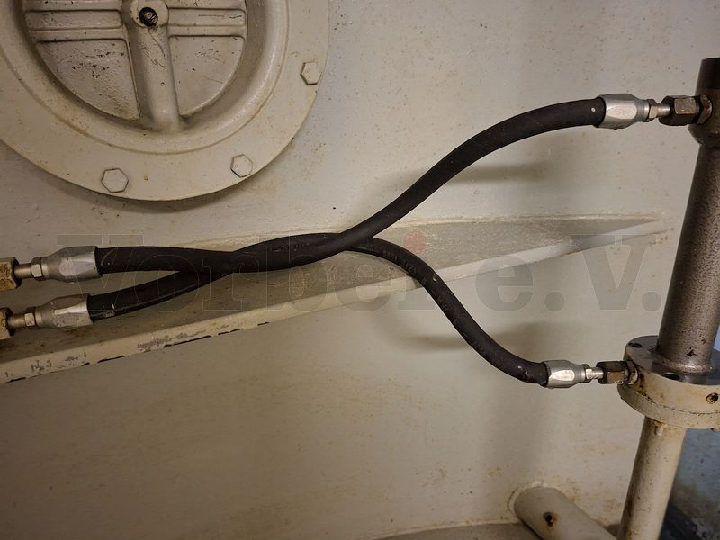 Der Hydraulikzylinder verfügt über zwei Anschlüsse. Beim Schließen der beiden Vorreiber wird der untere (jetzt defekte) Schlauch unter Druck gesetzt. Beim Öffnungsvorgang wird das Hydrauliköl durch den oberen Schlauch in den Hydraulikzylinder geführt. Der Hydraulikzylinder verfügt über zwei Anschlüsse. Beim Schließen der beiden Vorreiber wird der untere (jetzt defekte) Schlauch unter Druck gesetzt. Beim Öffnungsvorgang wird das Hydrauliköl durch den oberen Schlauch in den Hydraulikzylinder geführt.